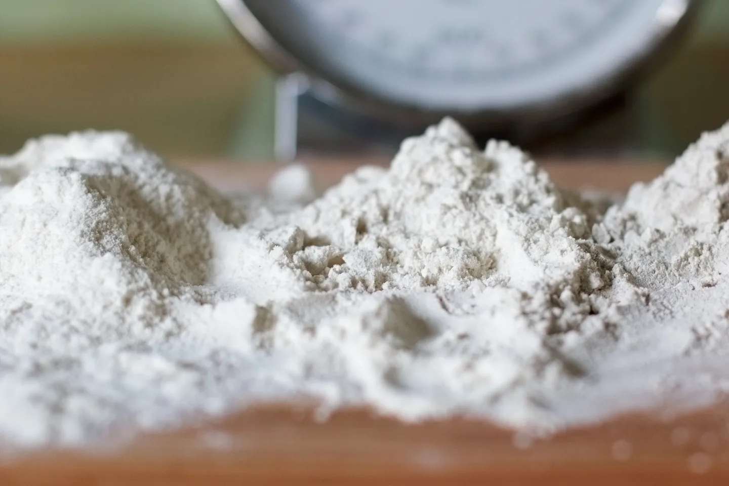 Three piles of flour, from pale wheat flour on the left to darker rye flour on the right