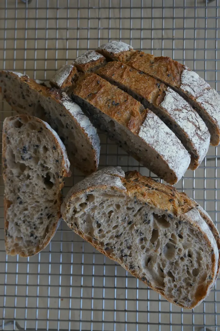 Sliced flour-dusted loaf on a cooling rack